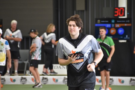 A UBC volunteer carrying a tablet beside the bowls green