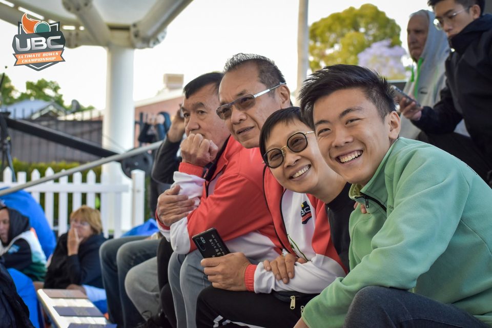 Family of supporters smiling together from the grandstand