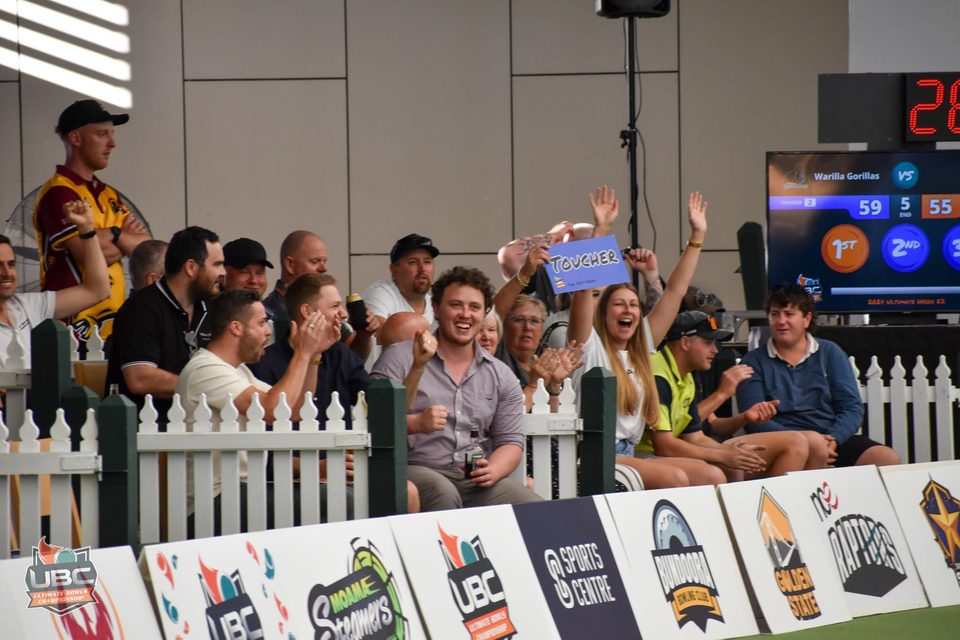Crowd cheering and holding up a Toucher sign behind the rinkside fence
