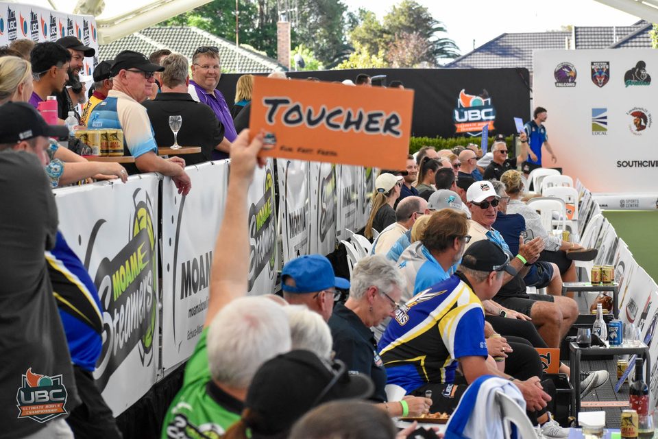 Spectator holding up a Toucher sign among the crowd lining the rink