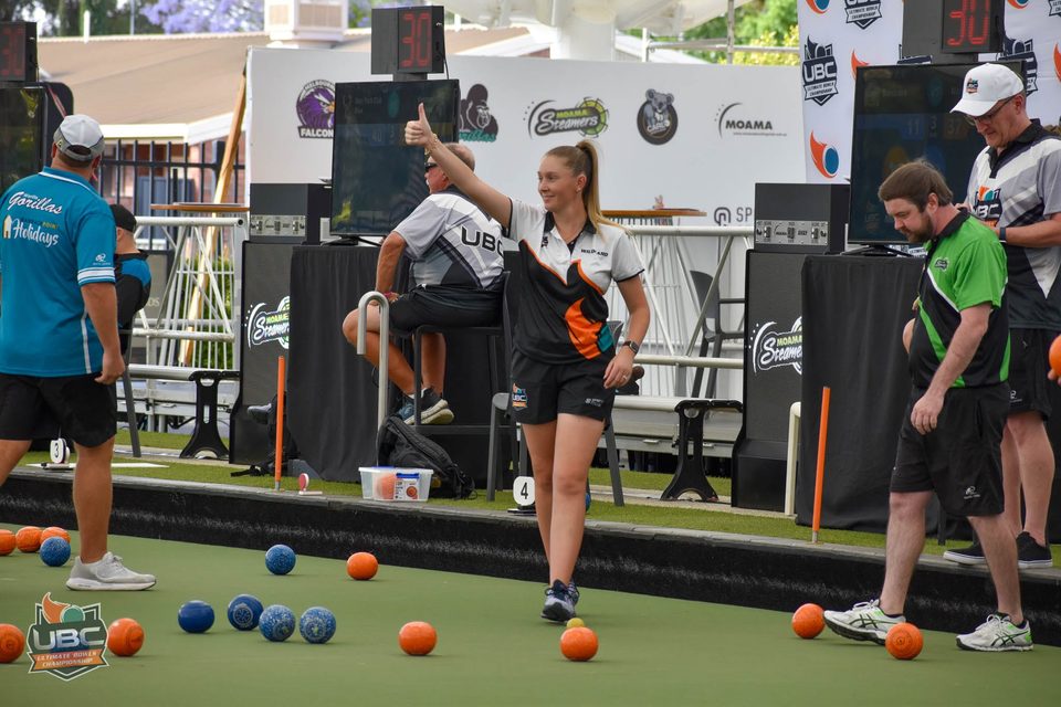 Player giving a thumbs up as she walks along the rink