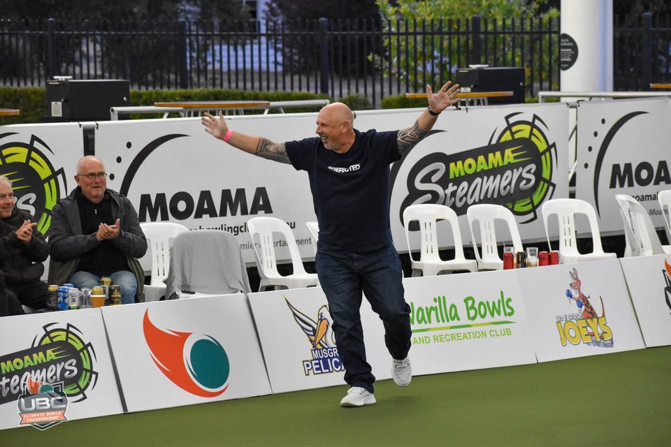 Player with arms spread wide celebrating in front of the Moama Steamers banners